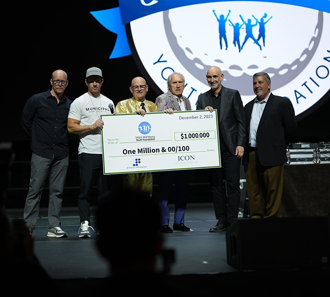 Group of People at Event Holding a Large Check